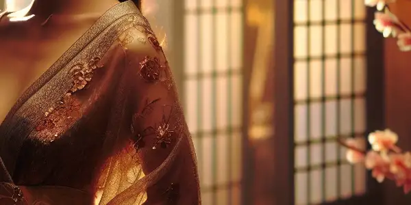 A beautifully dressed woman exudes charm in a romantic, softly lit Japanese setting with cherry blossoms and shoji doors.